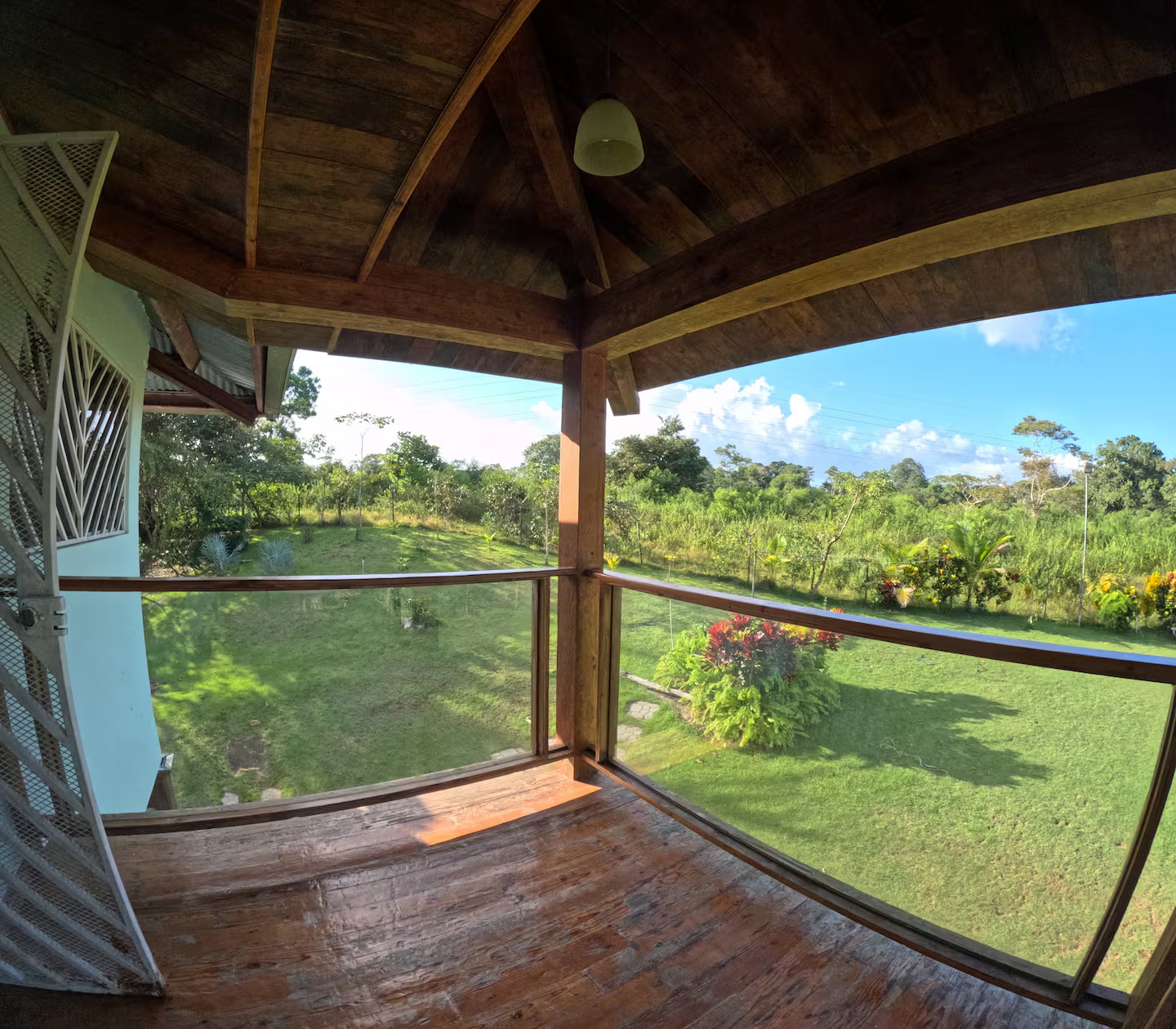 Balcón de madera con vista al jardín